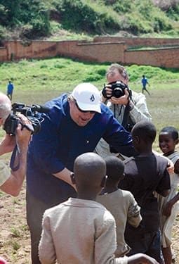 Rick Warren greets Kibuye-area children in the stadium where 10,000 Rwandans were murdered during the 1994 genocide. A new hospital has been built on the site as part of Saddleback Church