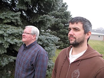 Jeff Browning (left) and Jon Pittman gaze at tornado damage that occurred near the church they serve in Washington, Illinois.