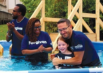 Ben Cachiaras hugs a girl after baptizing her.