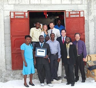 Jim Book (red tie), along with church members and other guests, help dedicate a new church building in Croix-des-Bouquets, Haiti.