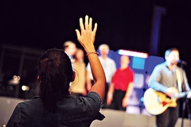 A woman worships along with the band and other singers at Gateway Christian Church, St. Louis, Missouri.