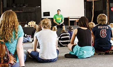A leader speaks to a group at the Neighborhood Life House in Joplin, MO, which seeks to be a stable and supportive place for children living in what a local minister calls a 