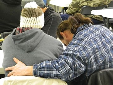 Two men pray before enjoying a free meal as part of the People In Need ministry in Virginia Beach, Va.