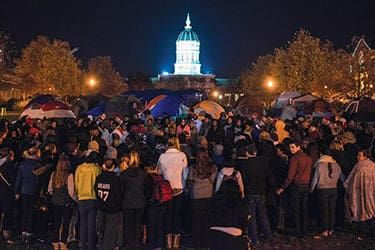 A large gathering circles up for group prayer for hunger striker Jonathan Butler and the community at the tent camp November 8, 2015, on the University of Missouri campus. This assembly occurred the same weekend the Missouri football team announced it wouldn