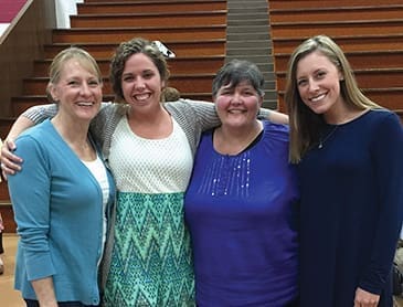 Anne Menear (second from right) is flanked by two of her students