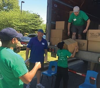 Volunteers with Journey Christian Church, Roswell, GA, participate in a food giveaway with Action Ministries.